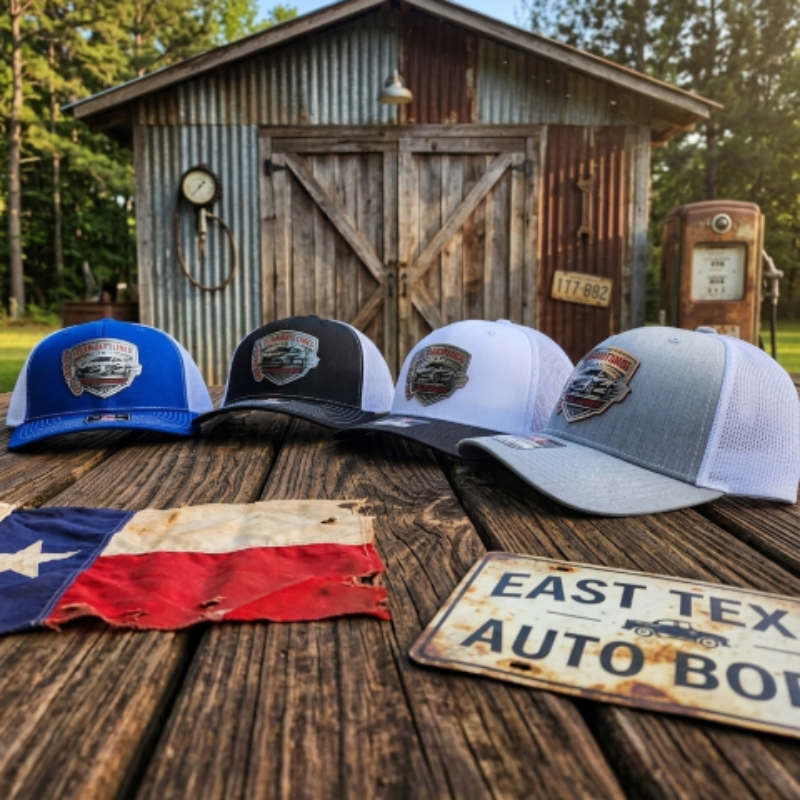 Four baseball caps with logos on a wooden surface in front of a rustic building.